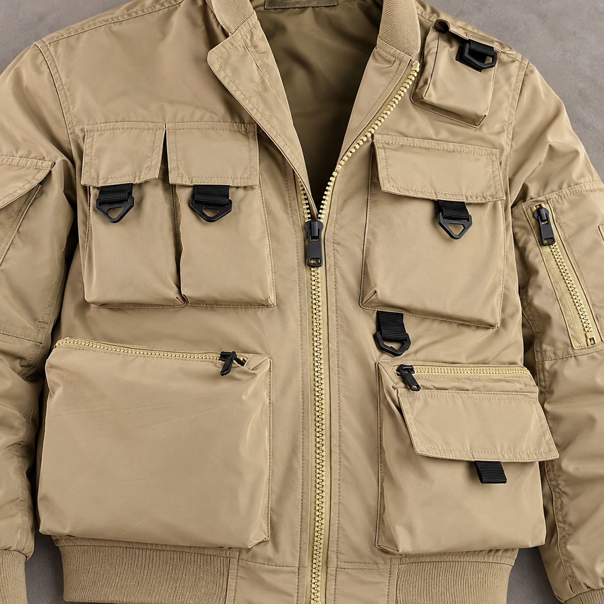 Close view of the khaki Phantom jacket cargo pockets, loops, seams and front zipper.
