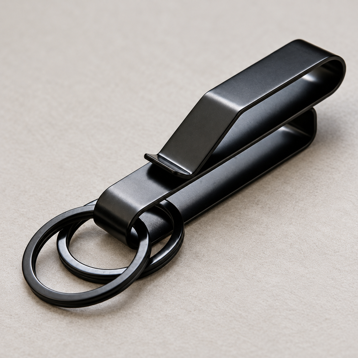 Close view of the Phantom belt clip showing its folded metal body, belt opening and two key rings.