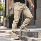 Phantom benefit stretch — Phantom IX7 khaki pants bending naturally at the knee as an adult man steps onto a low city stair.