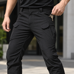 Phantom benefit pockets — Close view of an adult hand taking keys from a real pocket of Phantom IX7 black cargo pants.