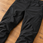 Phantom benefit cargo — Detail photograph of the diagonal zippered thigh pocket and stitched panels of Phantom IX9 black pants.