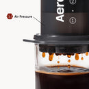 Detalle del café goteando a través de AeroPress hacia una taza