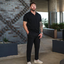 Hombre usando Casual Chinos V2 negros con un polo negro