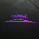 Logotipo Cybertruck morado proyectado sobre una superficie de concreto