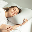 Mujer durmiendo de lado con una almohada blanca contorneada