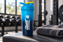 Coctelera azul GHOST en un banco de gimnasio junto a una toalla enrollada