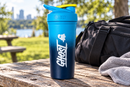Coctelera azul GHOST en una mesa de picnic al aire libre junto a una bolsa y una toalla