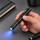 Linterna tipo lápiz SlimBeam sobre un escritorio con un haz azul