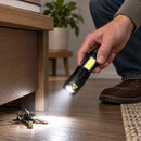 Mano usando la linterna Mini Titanium Laser para iluminar un piso