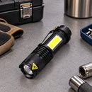 Linterna Mini Titanium Laser sobre un escritorio con luz frontal encendida