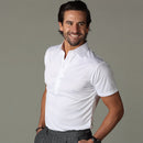 Hombre vestido con el polo blanco sobre un fondo de estudio neutro