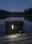 Luz lateral WUBEN X4 conectada a una caja de aparejos junto a aparejos de pesca en un muelle de madera