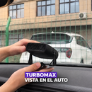 Aparato negro sostenido con las manos junto al tablero de un auto.