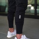 Primer plano de la parte inferior de las piernas de los joggers, el bolsillo utilitario y los puños ajustados en los tobillos.