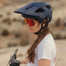 Mujer usando lentes de sol Ramble y casco de ciclismo