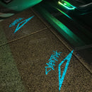 Logotipo Cybertruck cian proyectado junto a la puerta abierta del vehículo