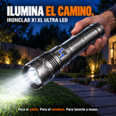 Mano sosteniendo una linterna IRONCLAD que ilumina el césped de un jardín, con título y leyenda en español.
