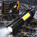 Linterna Mini Titanium Laser con luces frontales y laterales junto a su caja en una escena de salpicaduras de agua