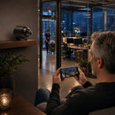 Hombre monitoreando una habitación de forma remota con su teléfono por la noche