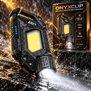 Linterna de llavero negra Onyxclip LED y COB junto a su caja en una escena de salpicaduras de agua