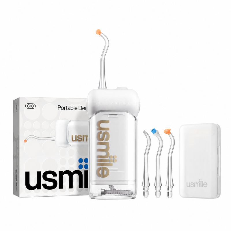 Irrigador bucal usmile C10 transparente con boquillas, estuche y caja sobre fondo blanco.