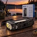 WUBEN X4 negro con su caja junto a una caña de pescar y un señuelo en una mesa junto al lago al atardecer