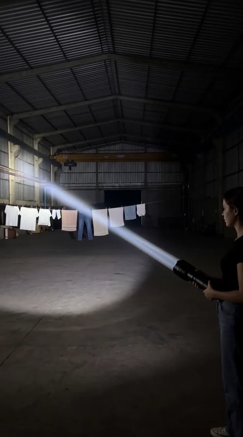 Hombre demostrando un haz de luz brillante dentro de una nave industrial grande